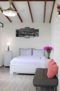 1 dormitorio con cama blanca y sofá en Modern apartment/Studio, en Pereira