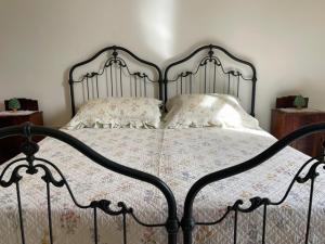a bedroom with a metal bed with two pillows at Casetta Parini in Porto Cesareo