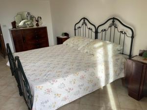 a bedroom with a large bed with a floral bedspread at Casetta Parini in Porto Cesareo +12 photos
