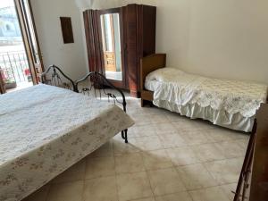 a bedroom with two beds and a window at Casetta Parini in Porto Cesareo