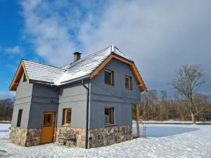 uma pequena casa azul na neve em Stadelnieki em Stadelnieki