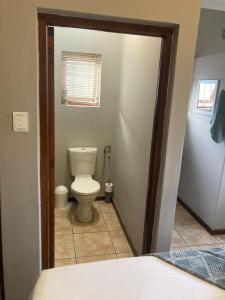 a bathroom with a toilet in a room at Eike Cottage in George