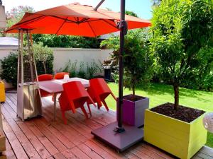 um pátio com uma mesa, cadeiras e um guarda-sol em Appartement avec Jacuzzi - Climatisation - Parking em Bordeaux