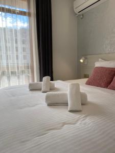 a bedroom with a large white bed with towels on it at GUEST ROOMS ASENEVTSI CITY CENTER in Veliko Tŭrnovo