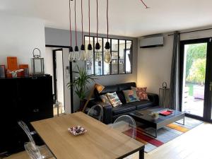 uma sala de estar com um sofá e uma mesa em Appartement avec Jacuzzi - Climatisation - Parking em Bordeaux