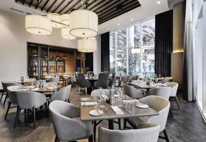 un restaurante con mesas, sillas y ventanas en Live! by Loews - Arlington, TX, en Arlington