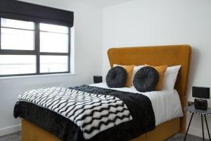 a bed with black and white sheets and pillows at Wellington House in Hull
