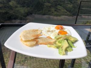 a plate of food with broccoli and eggs on a table at Glamping Mirador del Guavio in Ubalá
