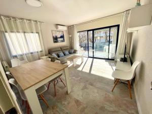 a dining room and living room with a table and chairs at Maria Voramar in Cambrils