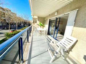 a balcony with two white chairs and a table at Maria Voramar in Cambrils