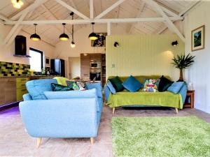 een woonkamer met twee blauwe stoelen en een bank bij The Cowshed in Merrymeet