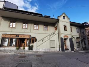 Un gran edificio blanco al costado de una calle. en Dům U Jelena, en Vimperk
