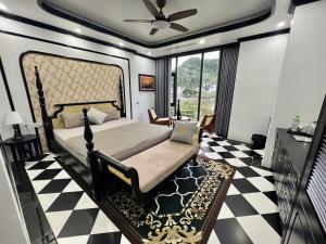 a bedroom with a bed and a black and white checkered floor at Quiri Hotel in Cat Ba