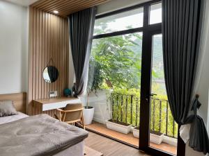 a bedroom with a bed and a large glass door at Quiri Hotel in Cat Ba