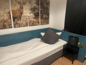 uma cama num quarto com três fotografias de um veado em Berghotel HARZ em Hahnenklee-Bockswiese