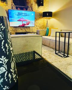 - un salon avec un canapé et une télévision dans l'établissement Ofek's place - Midtown TLV, à Tel Aviv