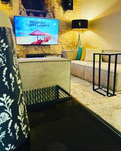 sala de estar con sofá y TV en Ofek's place - Midtown TLV, en Tel Aviv