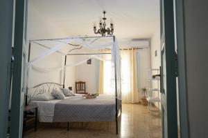 - une chambre avec un lit à baldaquin dans l'établissement B & B Agrigento antica, à Agrigente