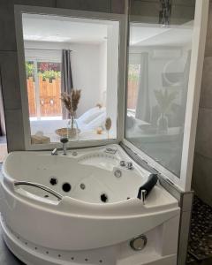 ein Badezimmer mit einem großen weißen Waschbecken und einem Spiegel in der Unterkunft Villa avec piscine entièrement rénovée à 5min de la plage de pinia in Ghisonaccia