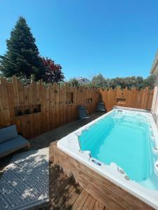einen Pool im Hinterhof mit einem Holzzaun in der Unterkunft Villa avec piscine entièrement rénovée à 5min de la plage de pinia in Ghisonaccia