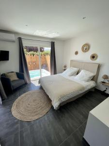 ein Schlafzimmer mit einem Bett, einem Stuhl und einem Fenster in der Unterkunft Villa avec piscine entièrement rénovée à 5min de la plage de pinia in Ghisonaccia