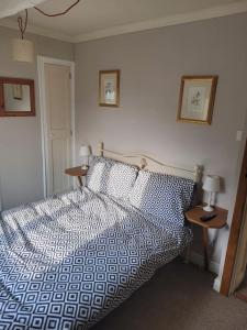 una camera con un letto e due tavoli con lampade di Two Bedroomed House near Newark & Grantham 