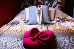 Una cama con toallas rosas encima. en ROMANTIC STUDIO EVE - PROCHE GARE - NETFLIX - WiFi, en Amiens