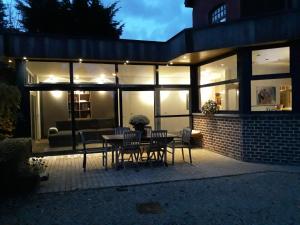 un patio con tavolo e sedie di fronte a una casa di Overijse’s cosiest double room a Overijse