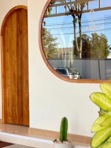 a round mirror on a wall next to a cactus at Teenan Hostel in Nan