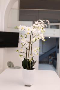 biała waza z białymi kwiatami na ladzie w obiekcie Parliament Exclusive Gallery w Budapeszcie