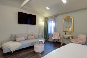 ein Wohnzimmer mit einem Sofa und einem Spiegel in der Unterkunft PALAZZO DUOMO Suites in Udine Center in Udine