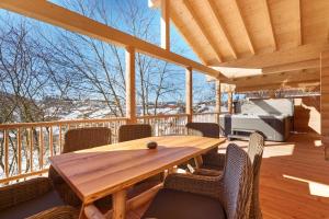 una terraza de madera con mesa y sillas de madera en Lederer Chalets, en Bodenmais