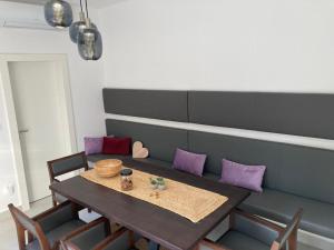 a dining room with a table and purple pillows at La BellaSu House in house in Sutivan