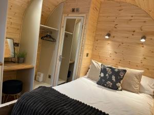a bedroom with a large bed with a wooden wall at New Farm Cheshire Holidays in Winsford