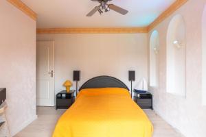 um quarto com uma cama com um cobertor amarelo em Chez Laurent em Épagny