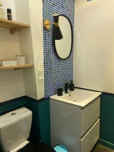 a bathroom with a toilet and a sink and a mirror at T3 moderne & proche stade de France, Adidas Arena in Saint-Denis