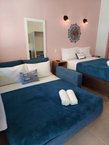 Pousada Astral في إيمبيتوبا: غرفة نوم بسريرين واريكة زرقاء