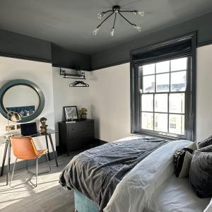 a bedroom with a bed and a mirror and a desk at Warwick St Studios in Leamington Spa