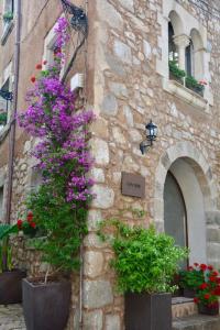 un edificio de piedra con flores a un lado en Can Senio 2 en Tossa de Mar