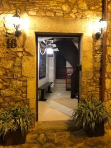 a hallway with a stone wall and a door with two plants at Can Senio 2 in Tossa de Mar