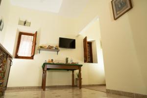 a room with a table and a tv on the wall at B & B Agrigento antica in Agrigento