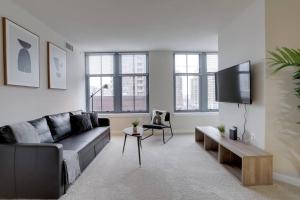 a living room with a couch and a tv at Bright and Cozy Apartment Near Pentagon City in Arlington