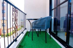 einem blauen Stuhl auf einem Balkon mit grünem Gras in der Unterkunft Nala House close to JKIA and SGR in Nairobi