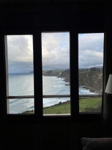 a view of the ocean from a bedroom window at La Colina in Gijón