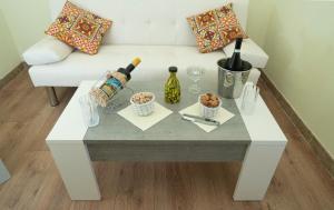 un tavolino bianco con bottiglie e bicchieri di B & B Agrigento antica a Agrigento