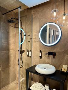a bathroom with a sink and a shower with a mirror at VENEZIANA Boutique Hotel Superior in Koper