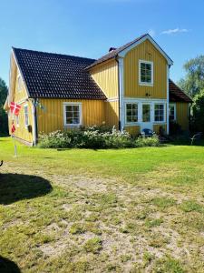 uma casa amarela com um quintal em frente em ELGGÅRDEN em Torup