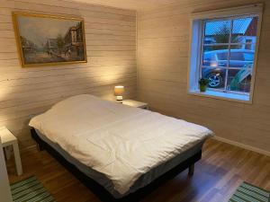 um quarto com uma cama e uma janela em ELGGÅRDEN em Torup