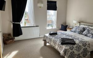 sypialnia z łóżkiem i 2 oknami w obiekcie Sixteen B w mieście York