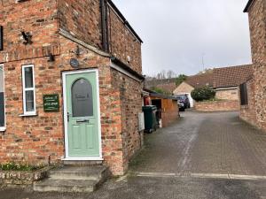 a brick building with a green door on a street at Sixteen B in York